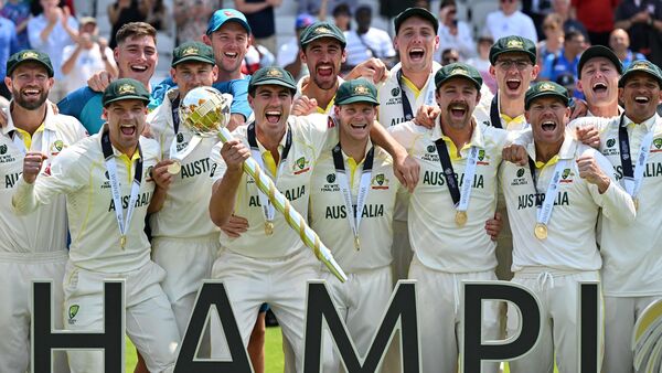 Australia's Pat Cummins (C) lifts the ICC Test Championship Mace as he celebrates with teammates after victory in the ICC World Test Championship cricket final match between Australia and India at The Oval (AFP)